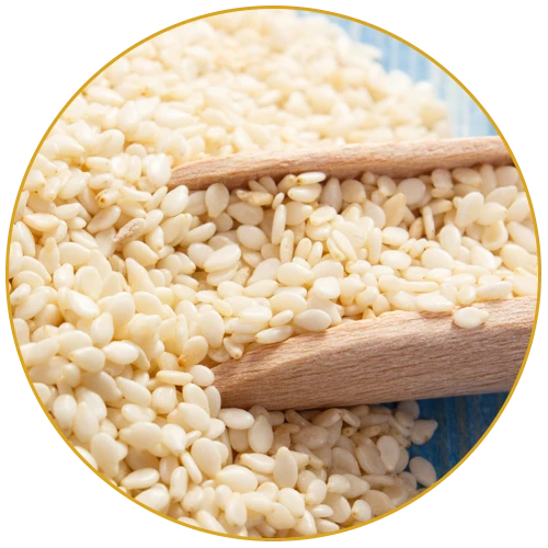 close-up of hulled sesame seeds in wooden spoon on blue surface